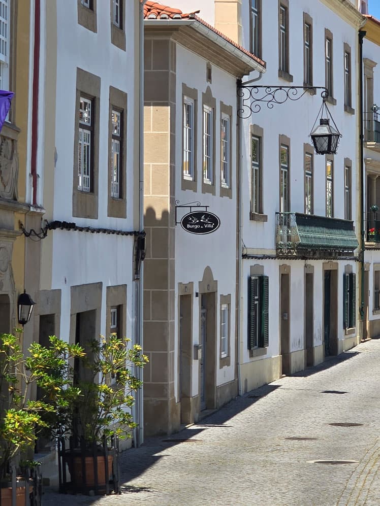 A narrow street of whitewashed houses with wrought-iron lanterns